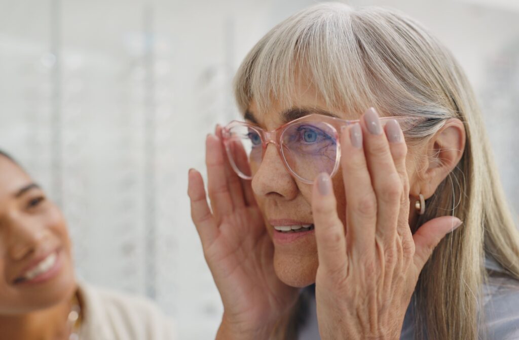 An optometrist assists a patient with her prescription glasses.