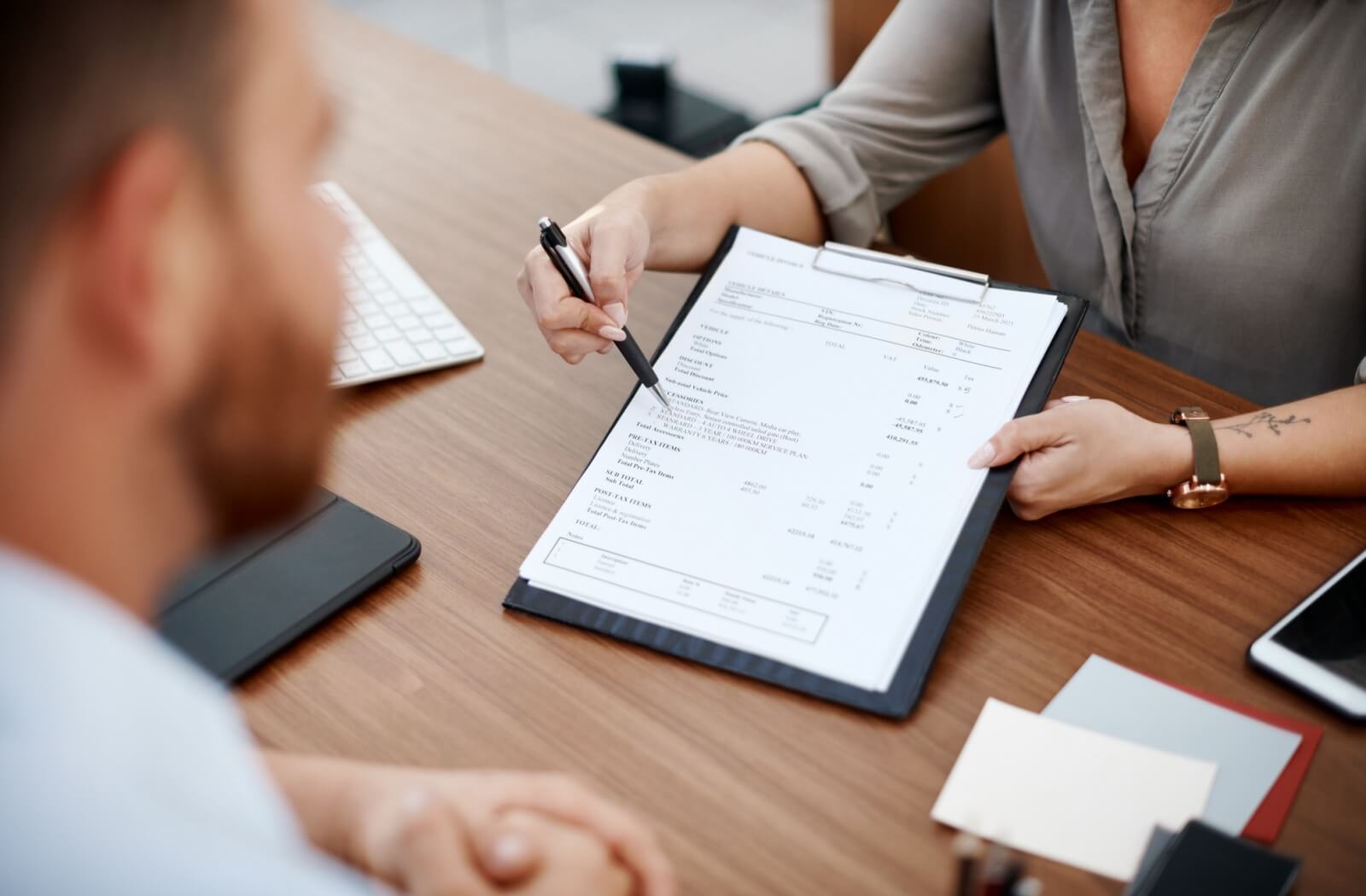 An optometrist reviewing a patient's coverage for their eye exam at a desk.